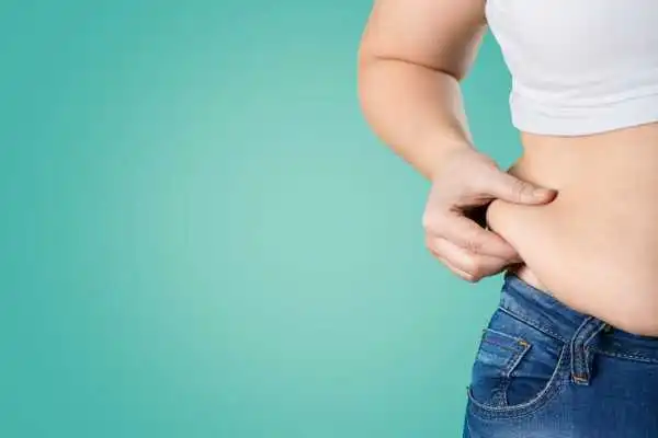 Image of woman pinching her love handles to show weight gain Macclesfield